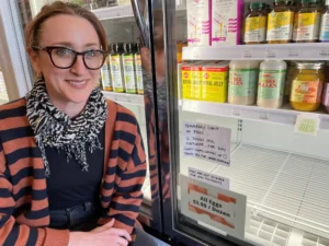 Lauren Gaffney, co-owner of Mastel's Health Foods in St. Paul, stands by a display fridge that usually would have a supply of eggs for sale. Gaffney said it's hard for her to keep eggs on the shelf.Mark Zdechlik | MPR News